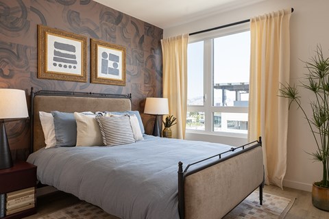 A bedroom with a large bed and a view of the balcony.