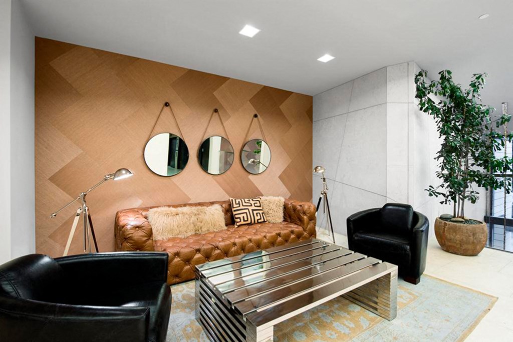 a living room with a brown couch and three mirrors on the wall