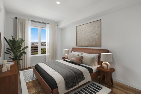 A bedroom with a large bed and a view of the outdoors through the window.