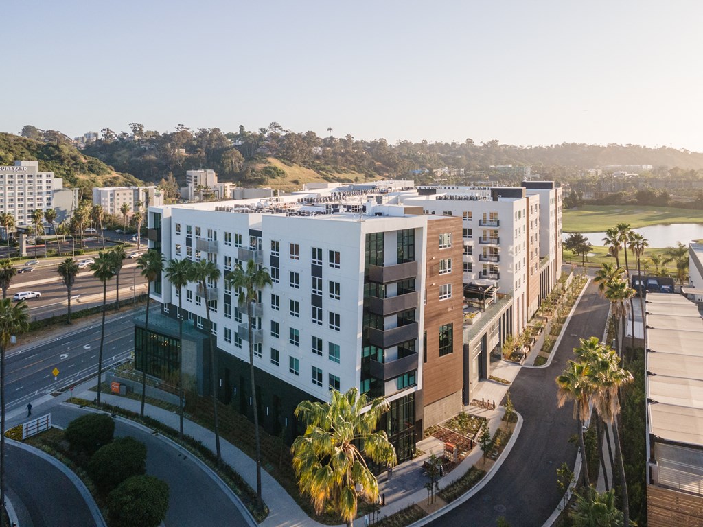 an aerial view of a building with palm trees in front of it