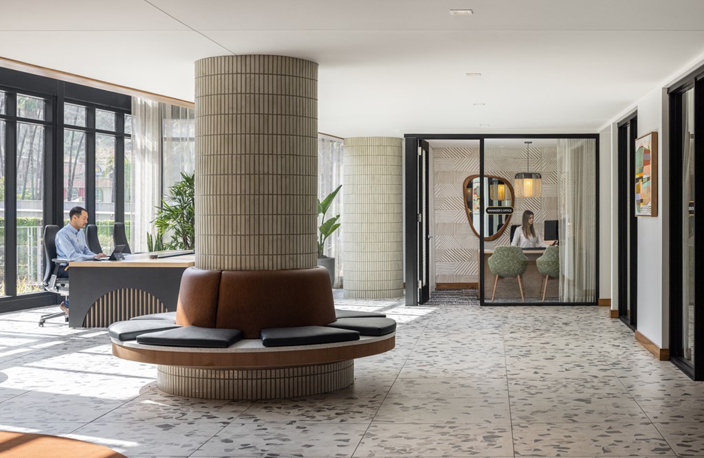 a pillar in the lobby of a hotel with a person sitting at a desk