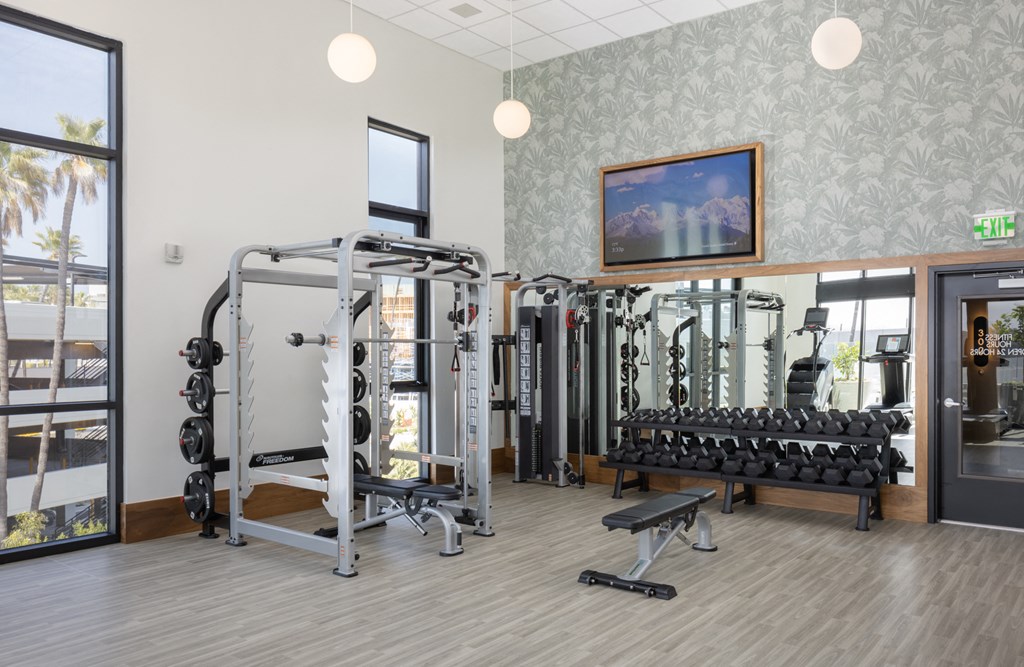 a gym with cardio machines and weights in the lobby of a building