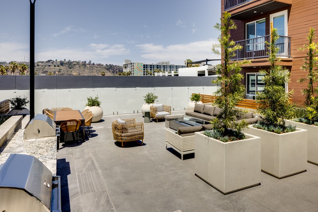 a rooftop patio with couches and tables and plants