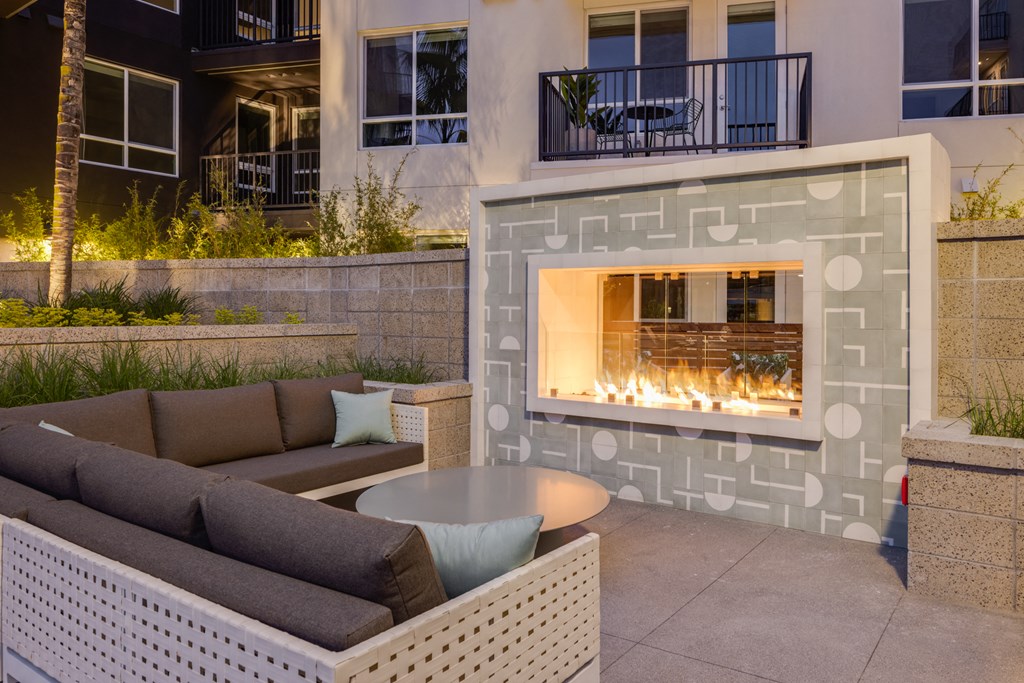 a patio with couches and a fireplace