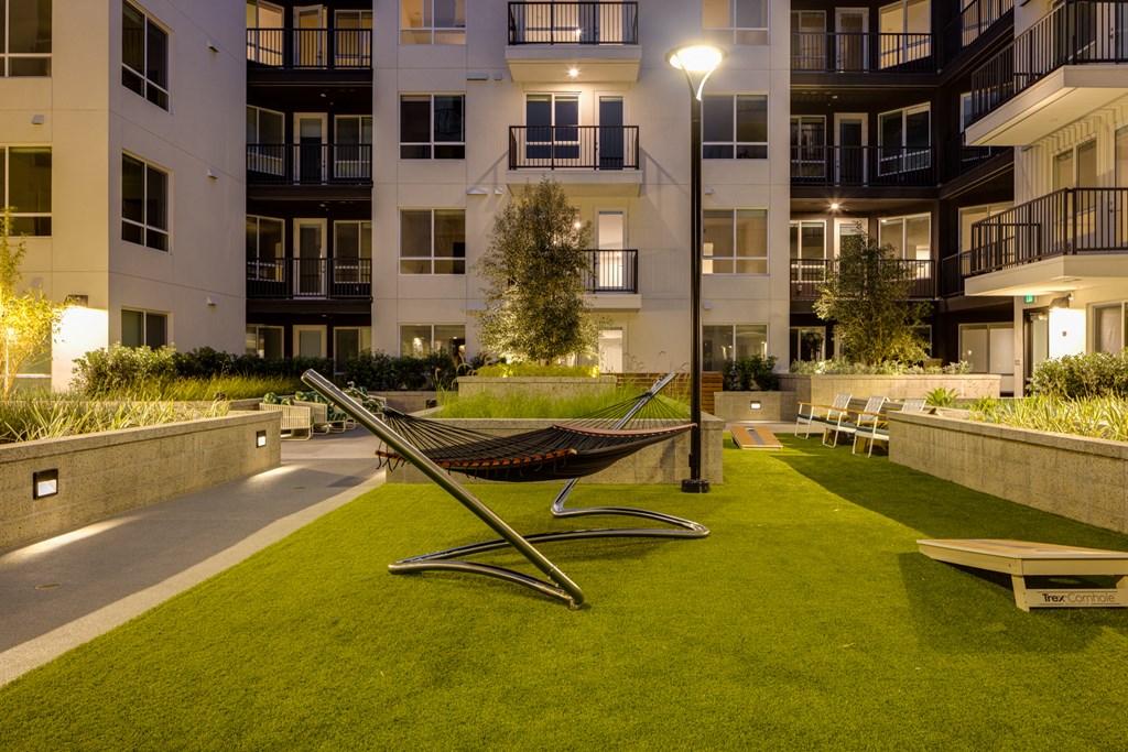a hammock in a park in front of an apartment building
