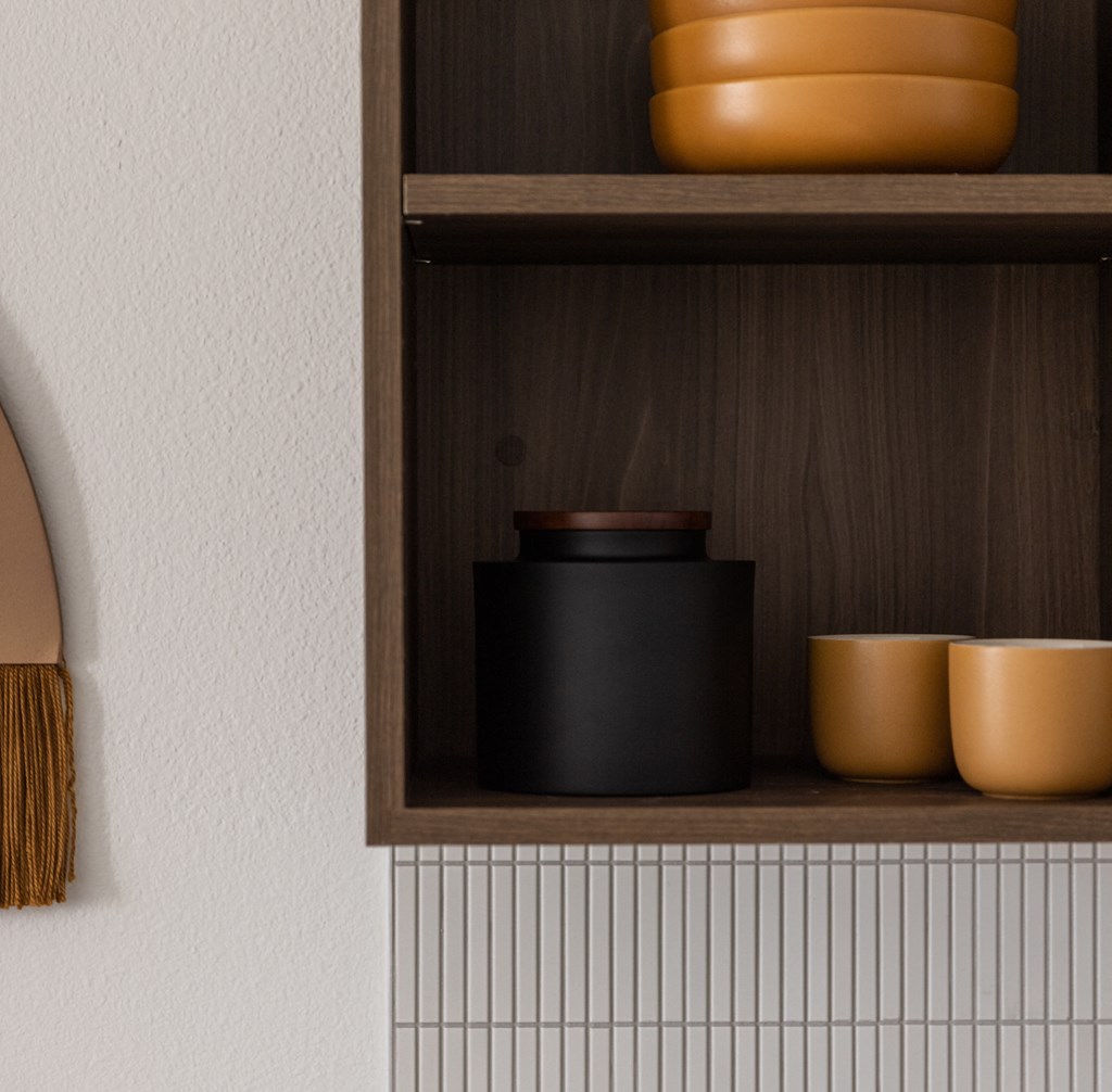 a shelf with a black pot and some clay pots on it