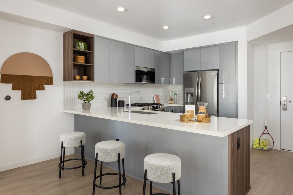 a kitchen with a large island with three stools