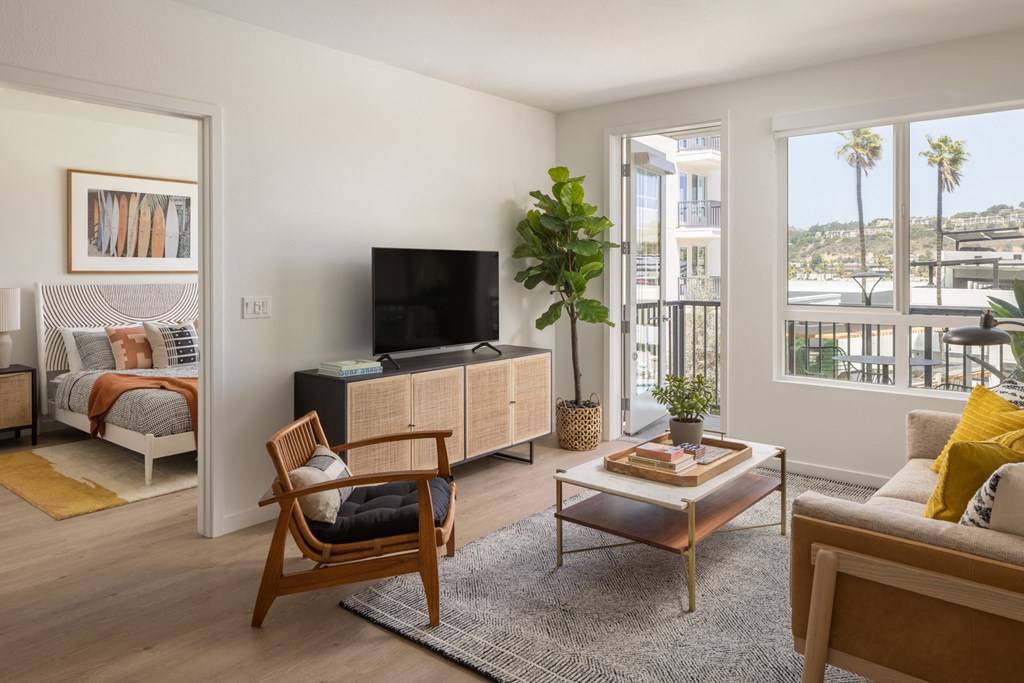 a living room with a couch and a television and a balcony