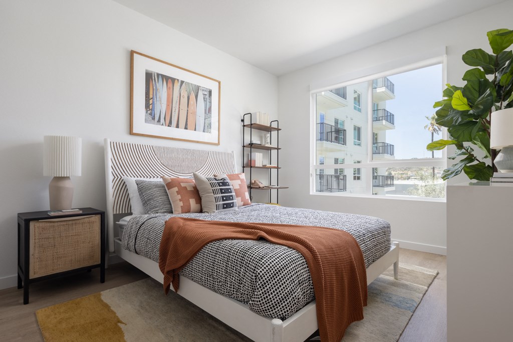 a bedroom with a bed and a large window