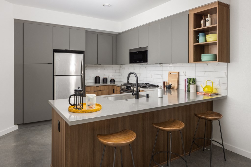 a kitchen with a large island with three stools