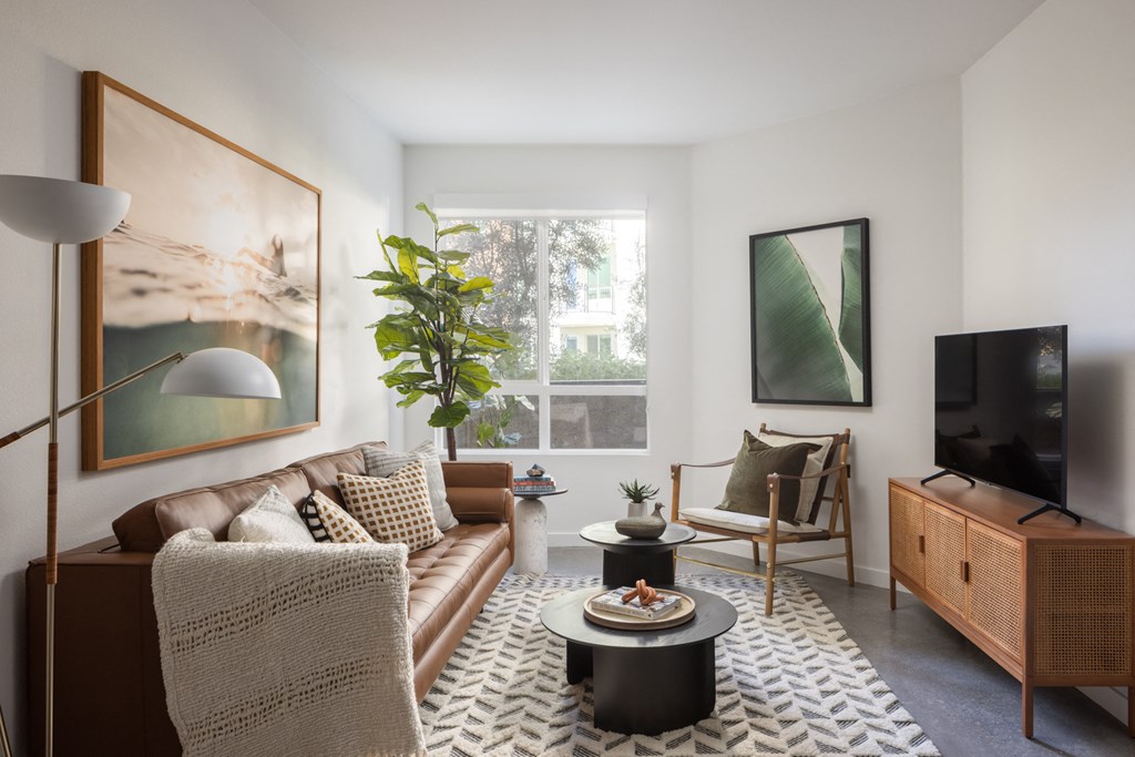a living room with a brown couch and a television