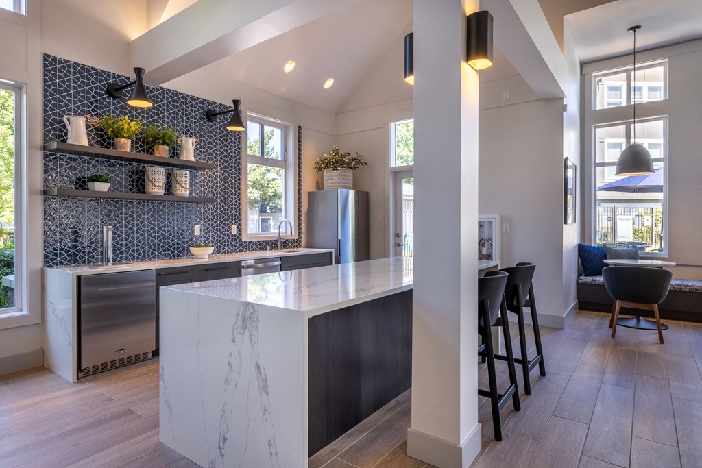 a kitchen with a large island and a living room in the background