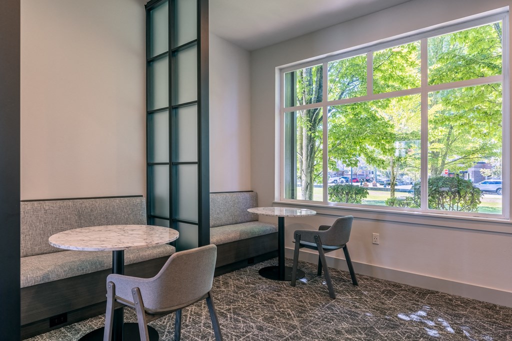 a room with tables and chairs and a large window