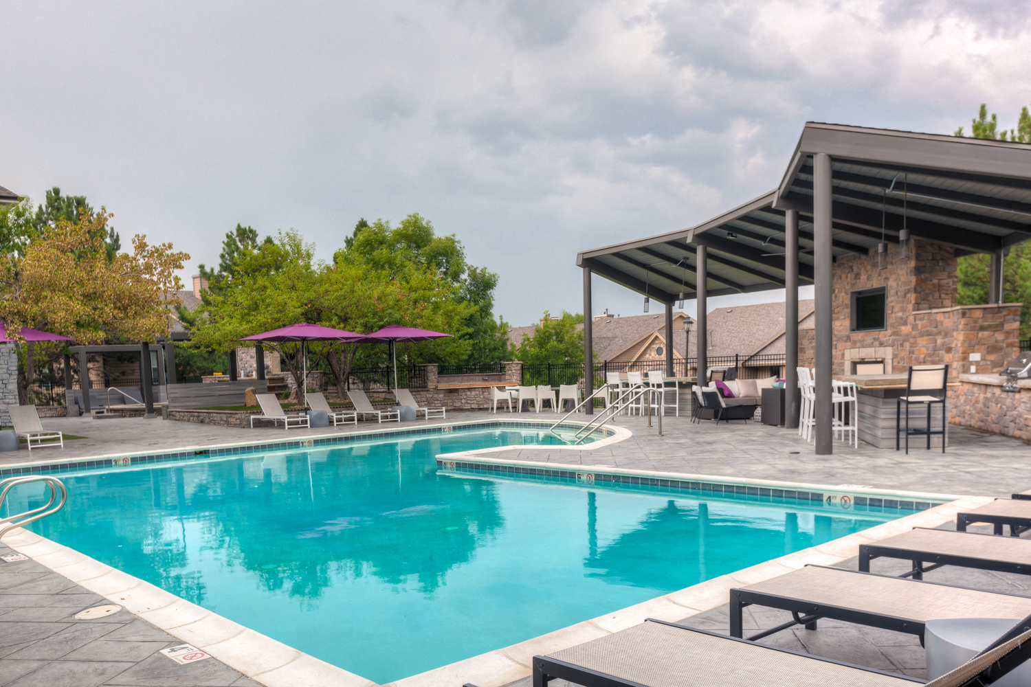 a swimming pool with chairs and umbrellas next to a resort style pool