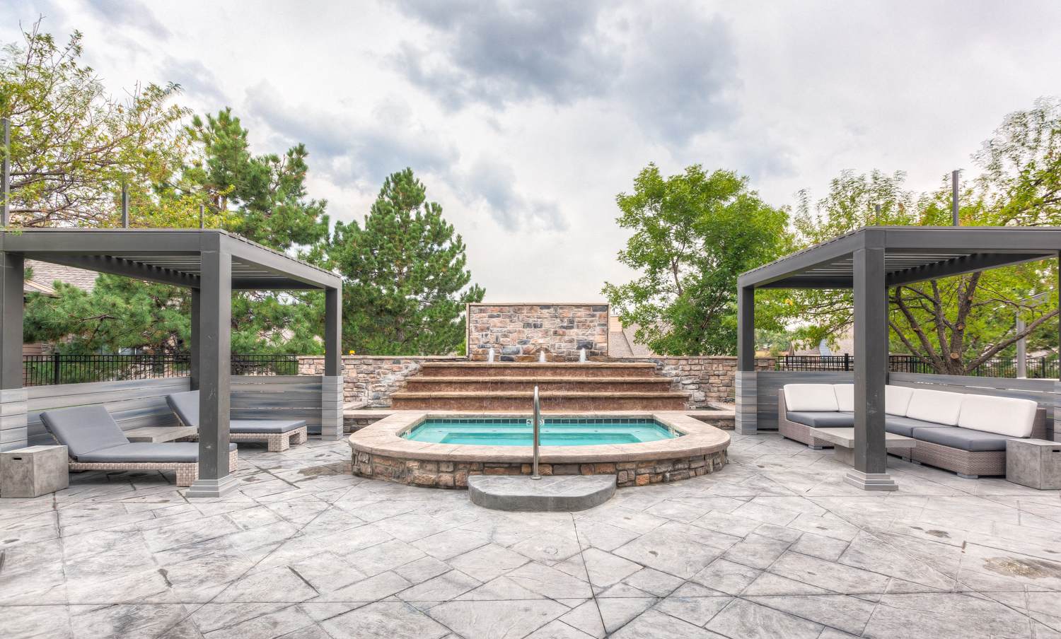 an outdoor patio with a pool and lounge furniture