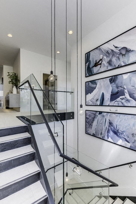 a glass staircase in a house with a painting on the wall