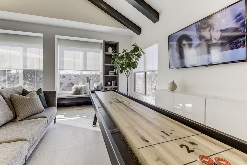 a living room with a long wooden table and a tv