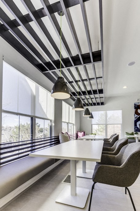 a white table and chairs in a room with large windows