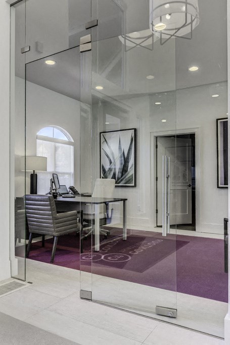 a glass walled office with a desk and a chair