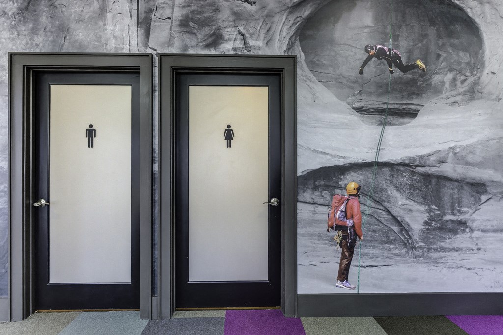 three elevators in a building with a mural of a man on a snowboard
