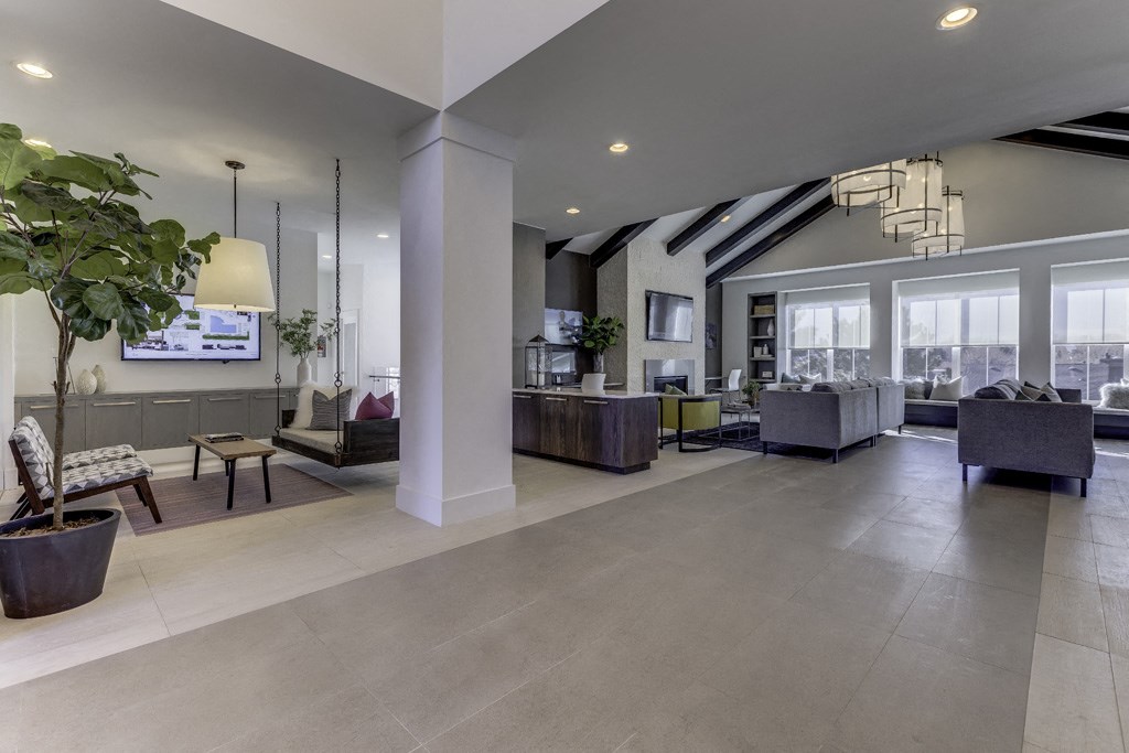 a large lobby with couches and chairs and a tv