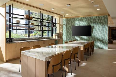 A modern kitchen with a long table and chairs.