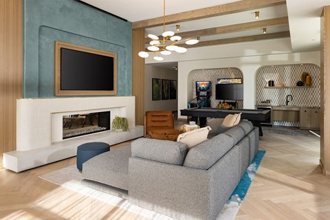 A modern living room with a grey sofa and a fireplace.