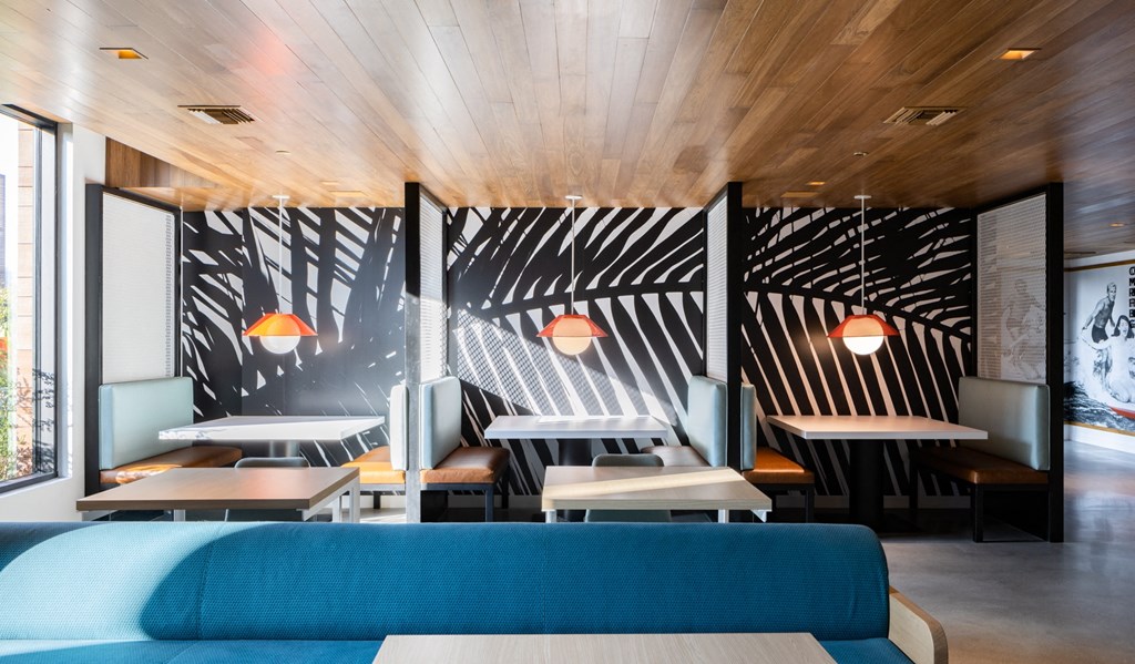 a dining room with tables and chairs and a large wall with a pattern on it