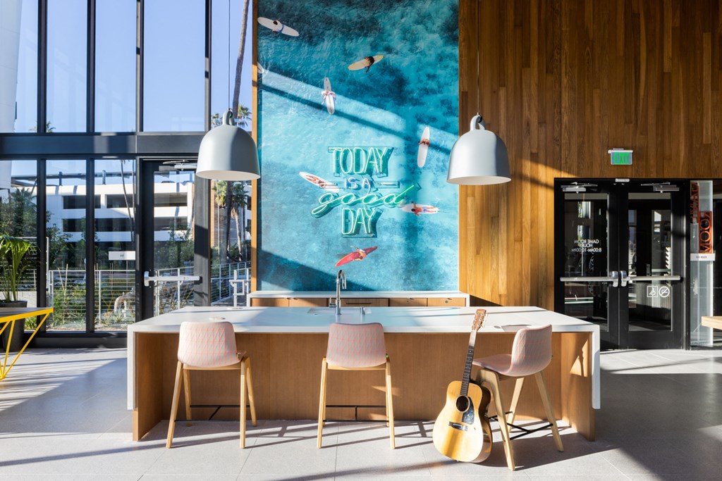 a large counter with chairs and a guitar in front of a wall with a mural
