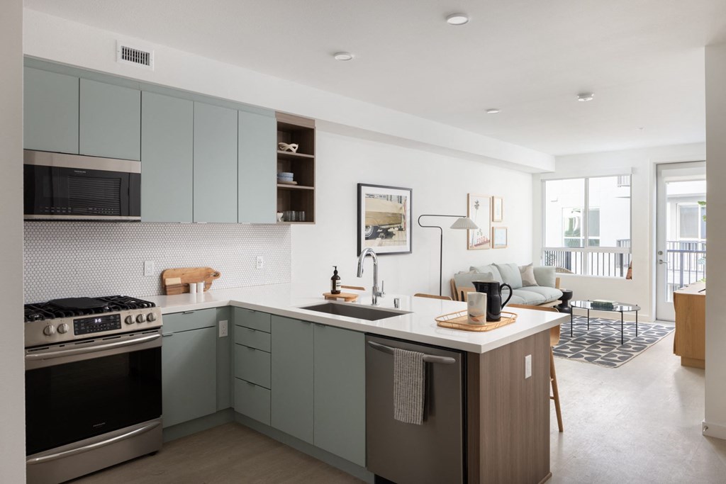 a kitchen with a sink and a stove and a living room