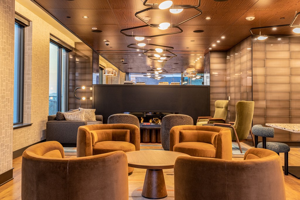 the lobby of a hotel with chairs and tables