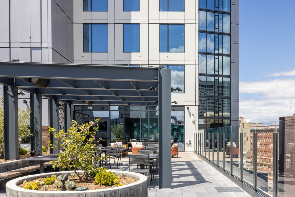 a patio with tables and chairs in front of a building
