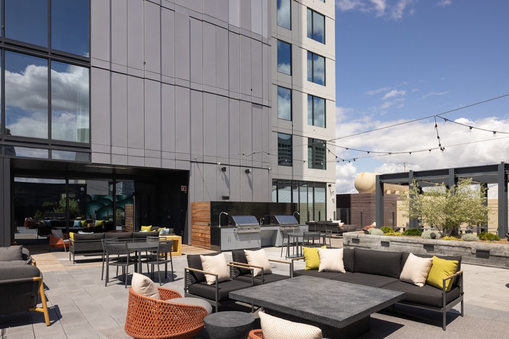 a patio with couches and tables outside of a building