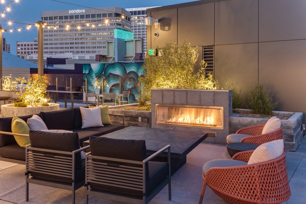 an outdoor patio with a fireplace and chairs and tables