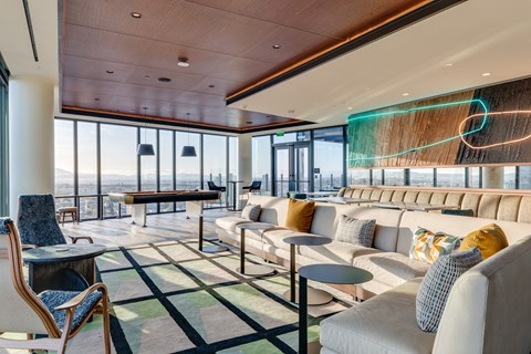 a living room with couches and tables and floor to ceiling windows