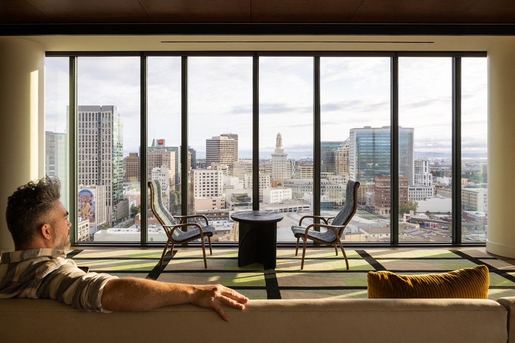 a man sitting on a couch in a living room with a view of the city