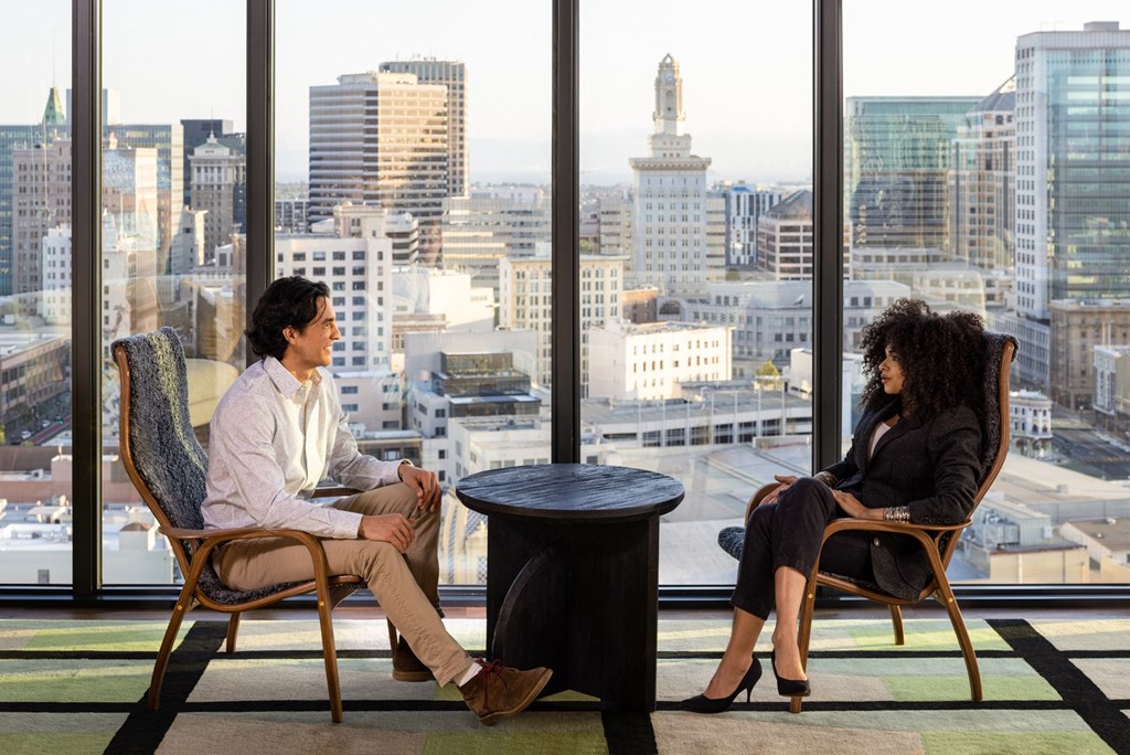 two people sitting at a table in front of a window