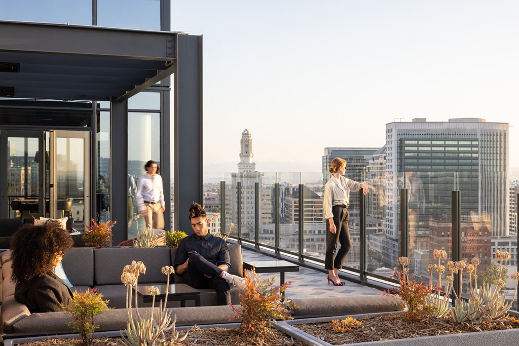 a group of people on a roof terrace overlooking the city