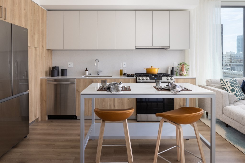 a kitchen with an island with two stools in front of it