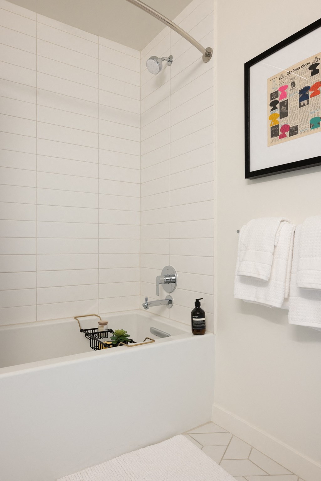 a small bathroom with a tub and a shower and a picture on the wall