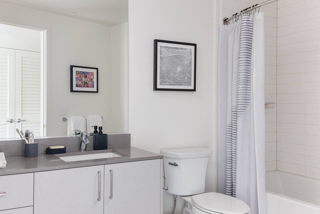 a white bathroom with a toilet sink and shower