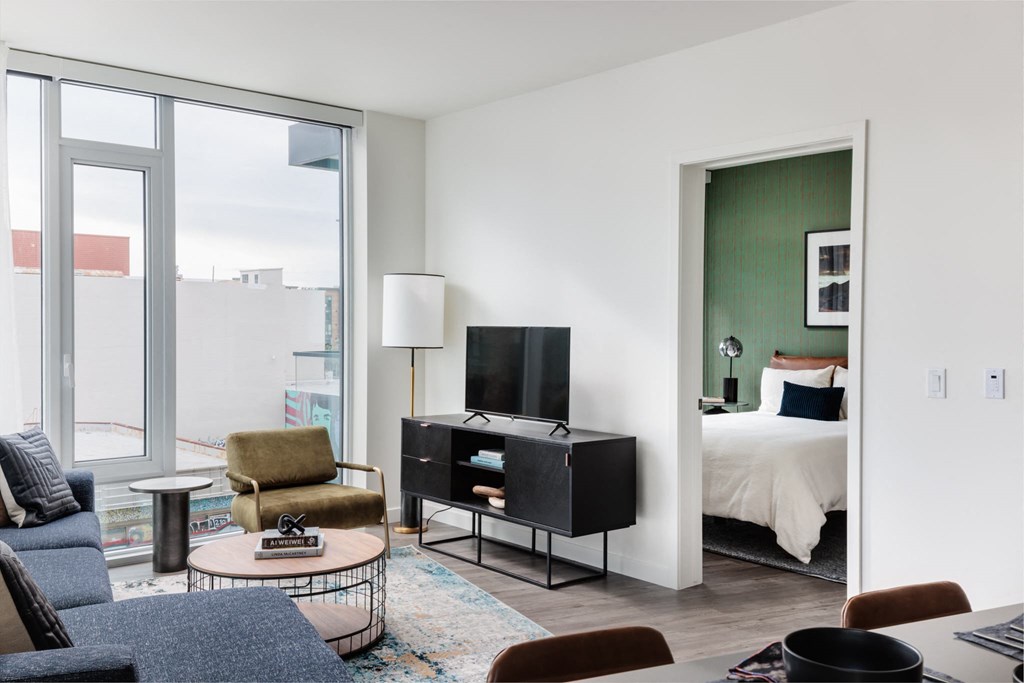 a living room with a bed and a door to a bedroom