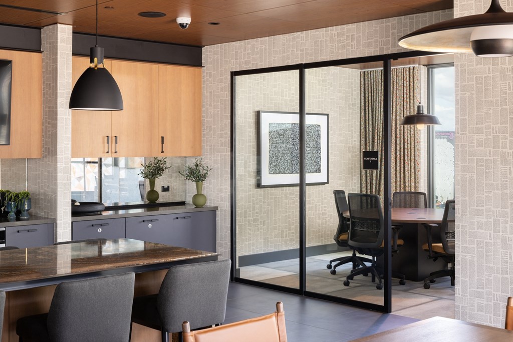 a dining room with a table and chairs and a conference room with glass doors