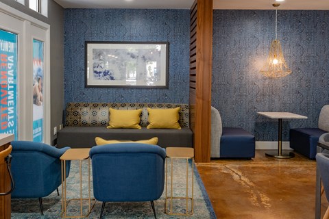 a living room with blue furniture and a picture on the wall