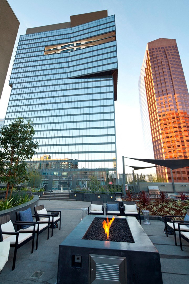a fire pit on an outdoor patio in front of a tall building