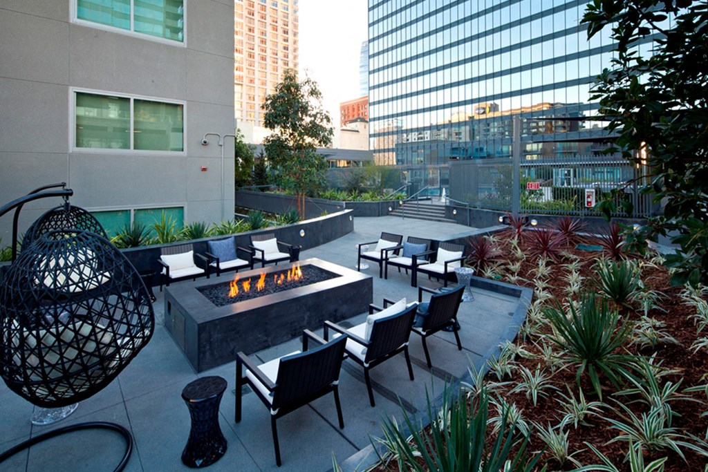 an outdoor patio with a fire pit and chairs