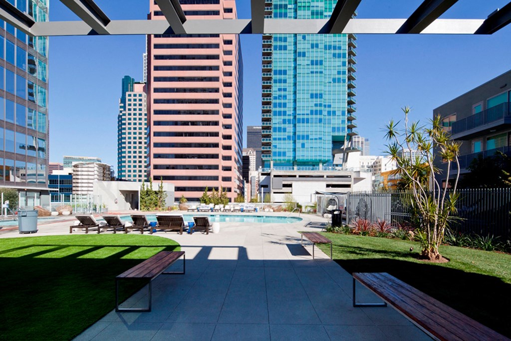 a view of the pool and city skyline from the patio of a high rise apartment building