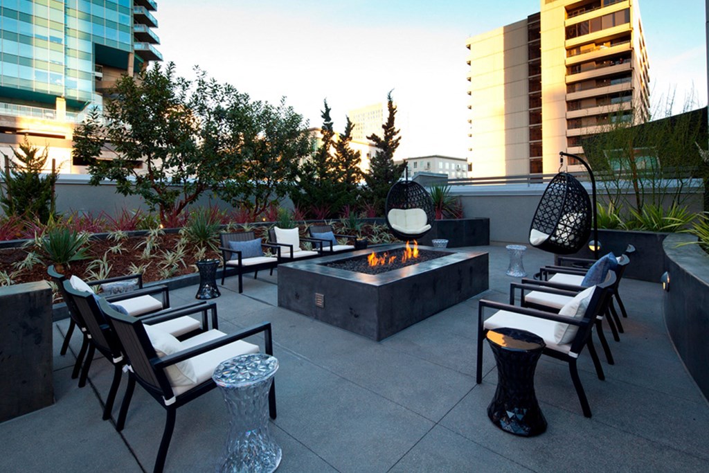 an outdoor patio with a fire pit and lounge chairs