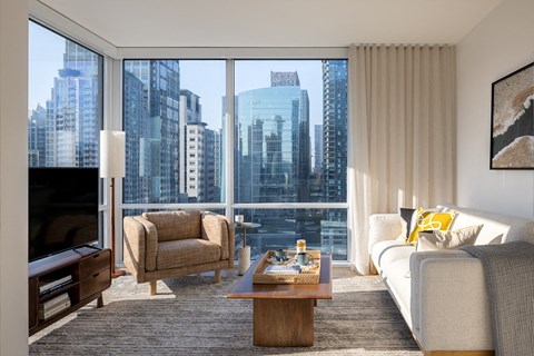 a living room with a city view and a couch and a table