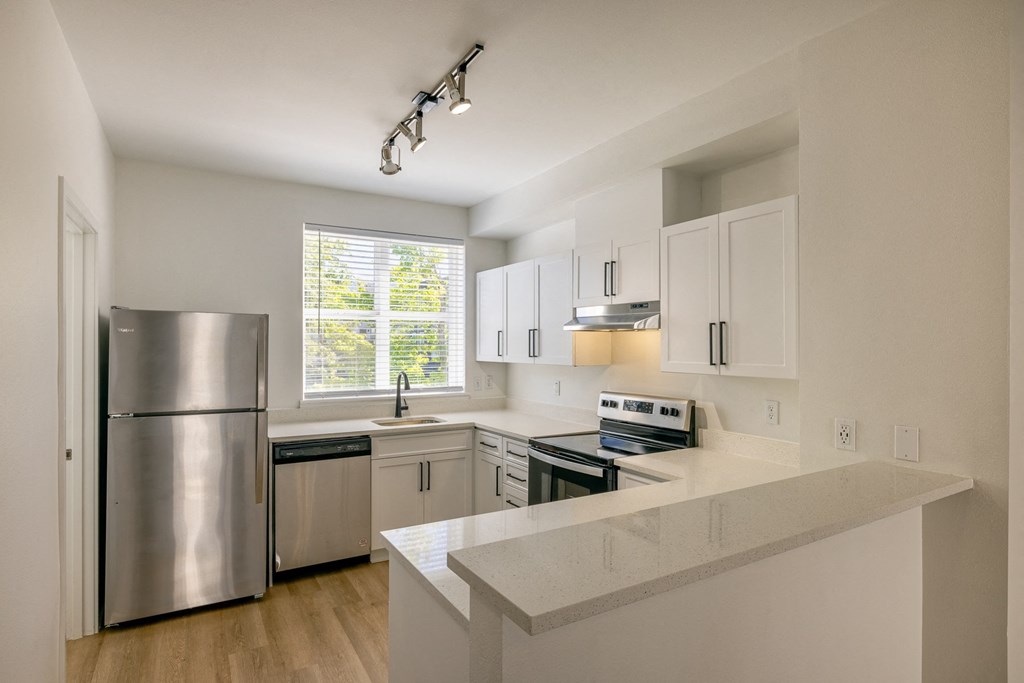a kitchen with white cabinets and stainless steel appliances